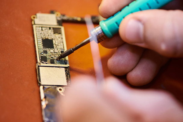partial view of technician soldering microscheme of electronic device in workshop, close up view - Photo, Image