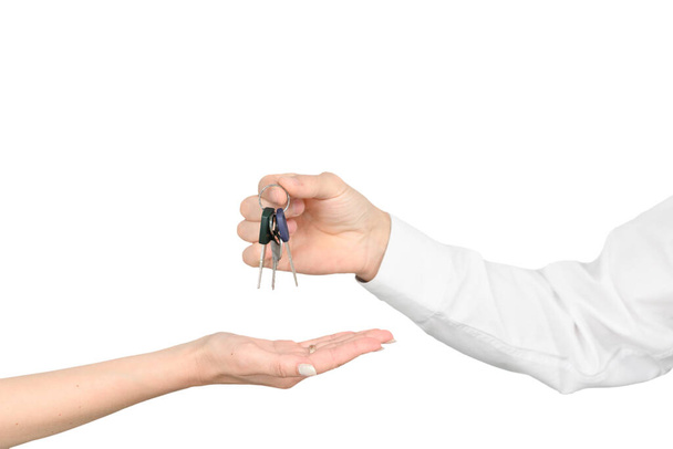Un homme donne les clés à une fille isolée sur fond de studio blanc, le concept de maquette immobilière. - Photo, image