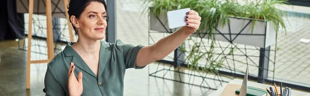 ελκυστική επιχειρηματίας σε casual ενδυμασία κυματίζει στο τηλέφωνο κάμερα κατά τη διάρκεια της κλήσης βίντεο, πανό - Φωτογραφία, εικόνα