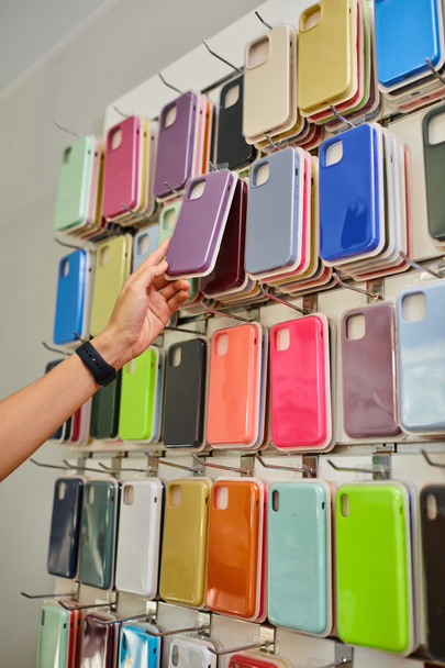 cropped view of salesman taking phone case from showcase in electronics and accessories shop, banner - Photo, Image