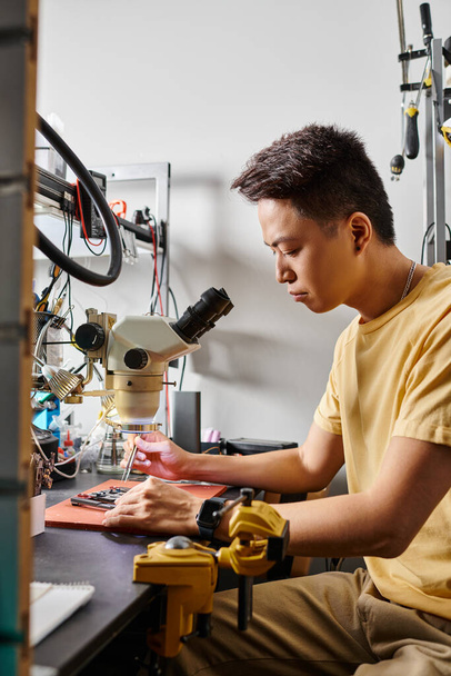 Atölyede mikroskop ve aletlerle çalışan deneyimli Asyalı tamirci, küçük işletme - Fotoğraf, Görsel