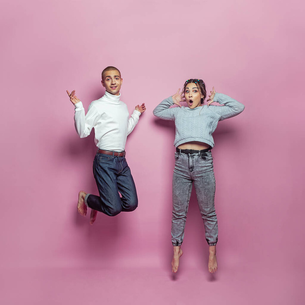 dwie osoby skaczące i uśmiechnięte na różowym tle - Zdjęcie, obraz