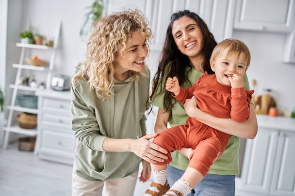 alegre pareja lesbiana en ropa de casa pasar tiempo junto con su hija en casa, familia - Foto, imagen