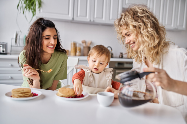 楽しい魅力的な lgbt カップル 彼らの赤ちゃんの女の子と美味しい朝食を持っている, 家族のコンセプト - 写真・画像