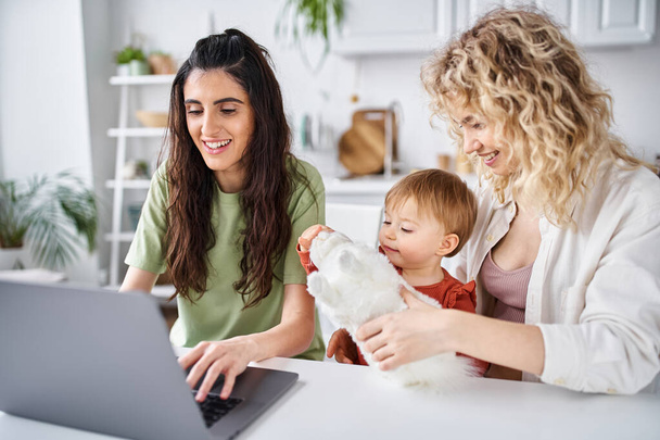 pielęgnowanie Lesbijki para w homewear oglądanie filmów z ich córeczką na laptopie, koncepcja rodziny - Zdjęcie, obraz
