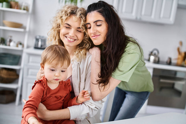happy attractive lesbian couple spending time together with their baby girl, family concept - Photo, Image