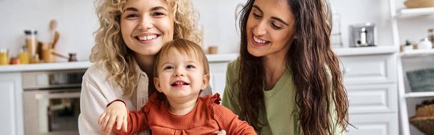 jolly lesbian couple in homewear spending time together with their pretty toddler daughter, banner - Photo, Image
