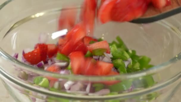 Шеф-повар смешивает овощную сальсу с клубникой в стеклянной миске - Кадры, видео