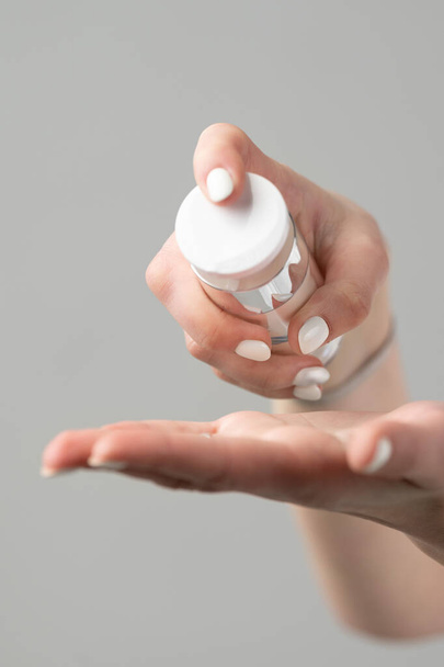 Kosmetikerin drückt Creme aus einem Glas auf die Hautpflege an Hand, Hand und Gesicht. - Foto, Bild