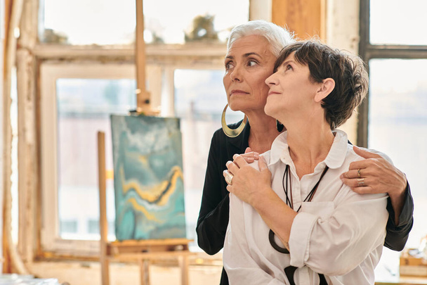 mietteliäs ja trendikäs lesbo taiteilijoiden katselee pois modernin taiteen studio luovia maalauksia - Valokuva, kuva