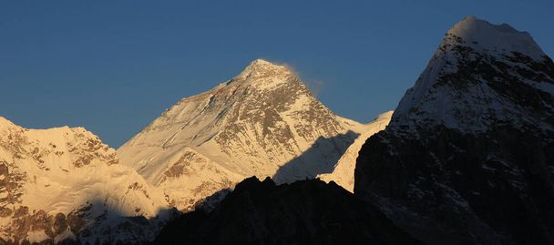 Heldere verlichte Mount Everest net voor zonsondergang. - Foto, afbeelding