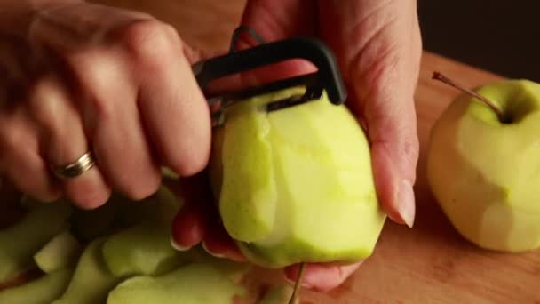 キッチンの女性はりんごケーキのリンゴを剥がします - 映像、動画