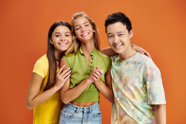 fröhliche hübsche multirassische Teenager in lässiger heller Kleidung, die in die Kamera schauen, Freundschaftstag - Foto, Bild