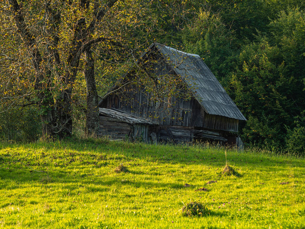 Old authentic wooden house with hayloft in scenic Carpathian mountains Ukraine, Europe, Transcarpathia region. Local countryside travel forest hiking trails. Cottagecore style vacation. Eco tourism. - Photo, Image