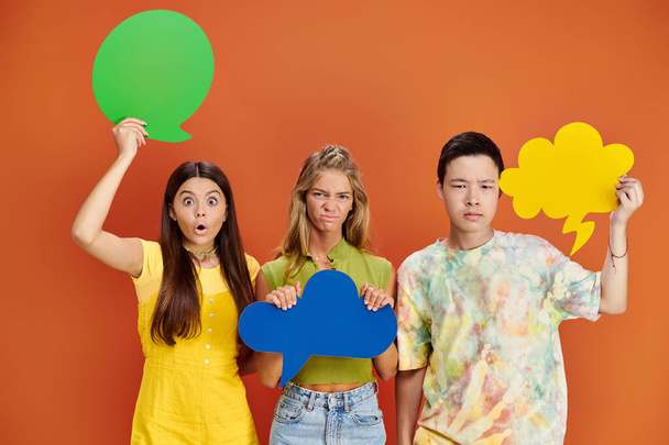 šokovaní a rozrušení různí teenageři držící různé myšlenky a řečové bubliny, den přátelství - Fotografie, Obrázek