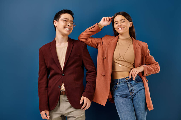 fröhliche, elegante multikulturelle Teenager in stylischen Outfits, die vor blauem Hintergrund lächeln, Freundschaftstag - Foto, Bild