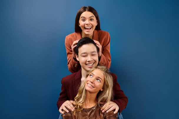 alegre diversos adolescentes en trajes elegantes sonriendo a la cámara mientras posan juntos, día de la amistad - Foto, imagen