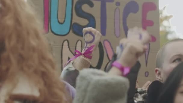 Грудь сообщества суфражисток поднимает кулаки с фиолетовыми феминистскими символами на них и выкрикивает инициативные лозунги, борясь за права женщин на открытом воздухе - Кадры, видео