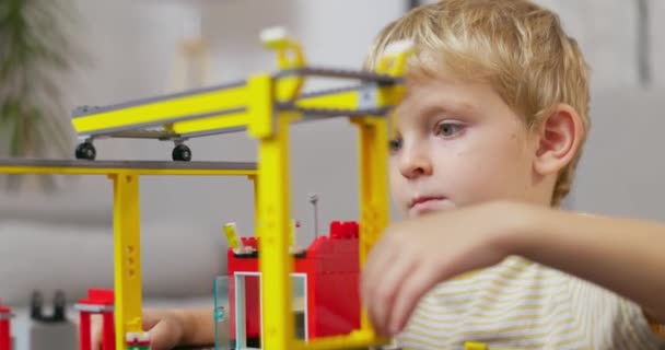 Bambino ragazzo che gioca e costruisce con mattoni di plastica colorati al tavolo. Apprendimento precoce e sviluppo. Filmati 4k di alta qualità - Filmati, video