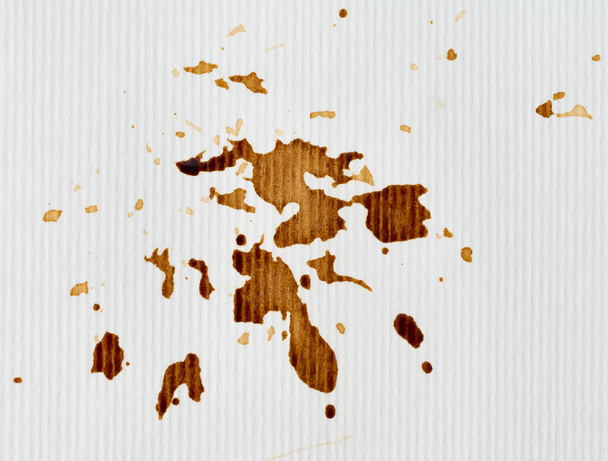 Розлита чорна кава на фоні білого паперу, краплі - Фото, зображення