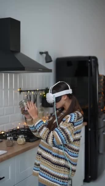 Dans une cuisine décorée pour Noël, une jeune femme cuisine en portant des lunettes de réalité virtuelle. Images 4k de haute qualité - Séquence, vidéo