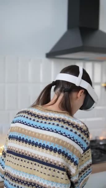 Betrokken bij het koken, draagt een jonge vrouw een virtual reality bril in een keuken in kerststijl. Hoge kwaliteit 4k beeldmateriaal - Video