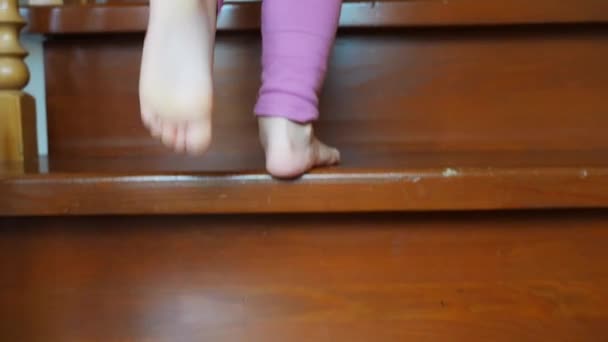 Zbliżenie stopy dziewczynki wchodzącej po schodach w domu, dziecko wchodzące po schodach. Wysokiej jakości materiał 4k - Materiał filmowy, wideo