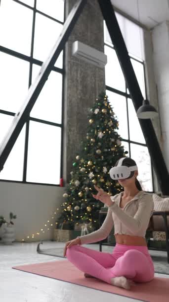 Молодая женщина учится пользоваться гарнитурой виртуальной реальности, подаренной ей на Рождество. Высококачественные 4k кадры - Кадры, видео
