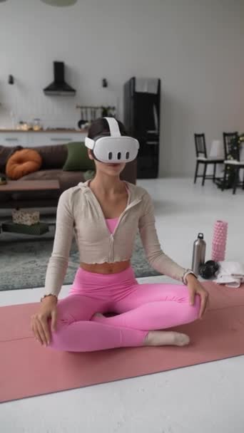 A fiatal nő éppen tanulja, hogyan kell kezelni a virtuális valóság headsetet, amit karácsonyra kapott. Kiváló minőségű 4k felvételek - Felvétel, videó