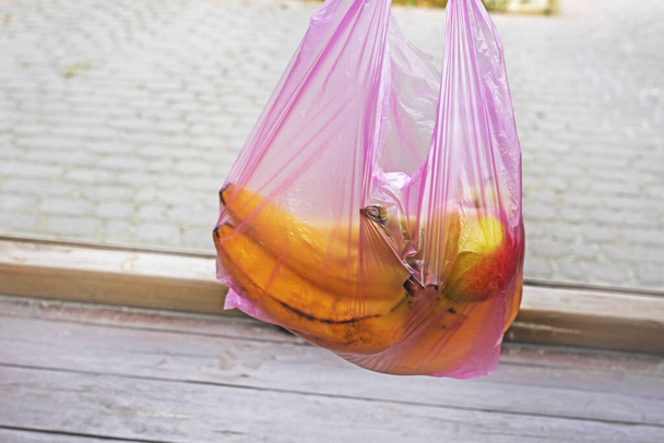 bananen in een plastic wegwerpzak bewaren. milieuecologen. winkelen in een winkel - Foto, afbeelding