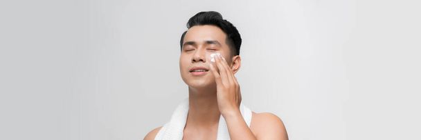 Young man with moisturizer on the face - Foto, imagen
