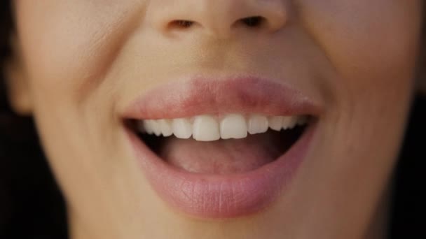 光沢のある自然なピンクの唇のセンセーショナルな女の子は魅惑的に唇を噛みます. セクシーなフラットレディースコンセプト。 さまざまな魅惑的な女性のショット映像を閉じます. セクシーな女性は舌で唇をライセンスします. 異なる女性 - 映像、動画