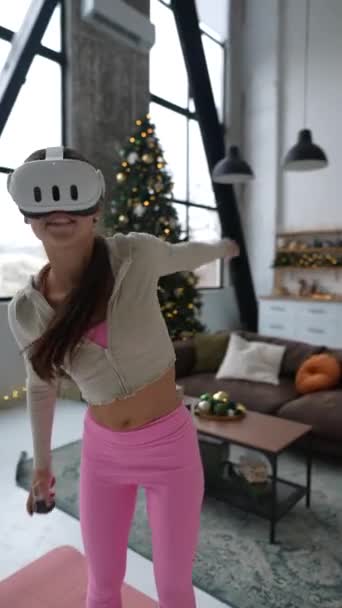Een jonge vrouw maakt gebruik van een virtual reality headset voor actieve sport tijdens de kerstvakantie. Hoge kwaliteit 4k beeldmateriaal - Video