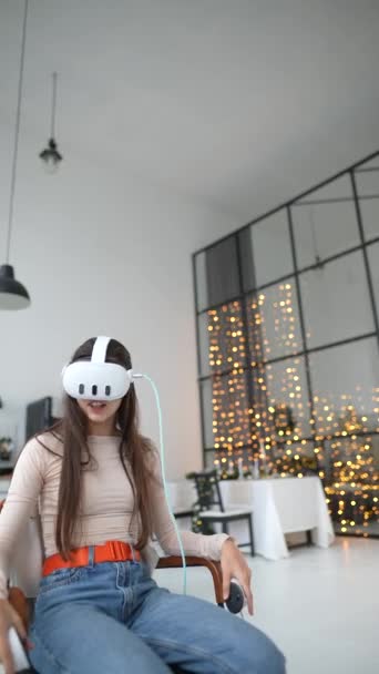 Женщина проводит рождественские каникулы, играя в видеоигру, используя гарнитуру виртуальной реальности. Высококачественные 4k кадры - Кадры, видео