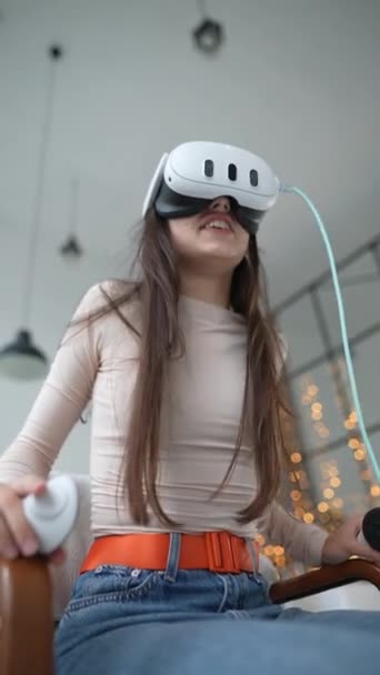 Egy nő tölti a karácsonyi ünnepeket játszik egy videojáték segítségével virtuális valóság headset. Kiváló minőségű 4k felvételek - Felvétel, videó