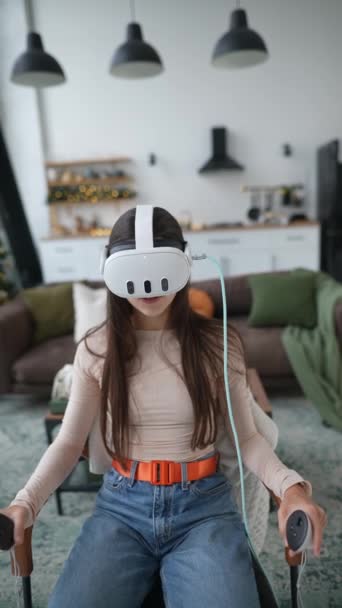 Une femme chic utilisant un casque de réalité virtuelle dans un appartement décoré du Nouvel An. Images 4k de haute qualité - Séquence, vidéo