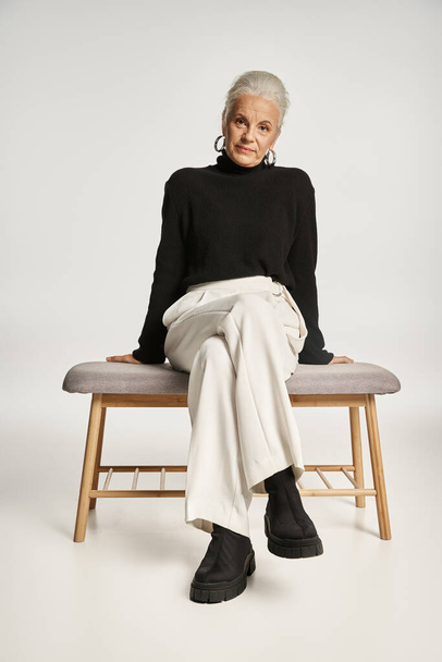 деловой портрет, счастливая деловая женщина средних лет в шикарной повседневной одежде, сидящая на внутренней скамейке - Фото, изображение
