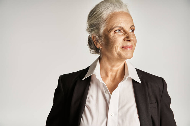 retrato de negocios de la feliz mujer de negocios de mediana edad en camisa blanca y chaqueta mirando hacia otro lado - Foto, imagen