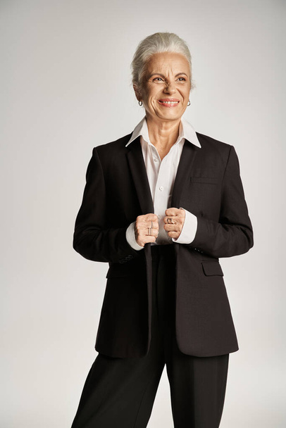 επιχειρηματικό πορτρέτο της ευτυχούς μεσήλικας επιχειρηματίας σε λευκό πουκάμισο και σακάκι κοιτάζοντας μακριά - Φωτογραφία, εικόνα