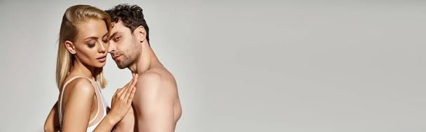 shirtless man with muscular body embracing beautiful woman on grey background, sexy couple banner - Photo, Image