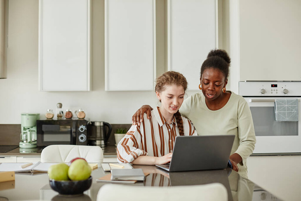 Portrait of two young women using laptop together at home while managing small business, copy space - Photo, Image