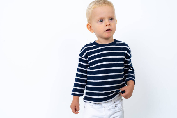 Studio portrait de beau garçon blond enfant portant col roulé rayé sur fond blanc - Photo, image