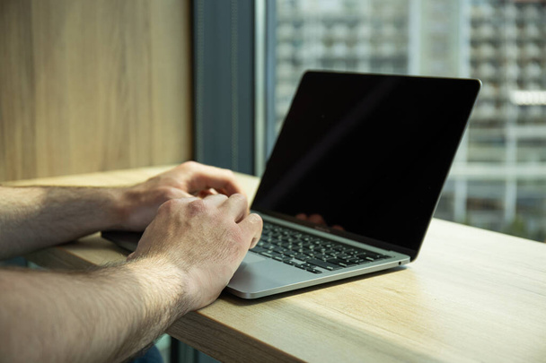 man hand op zwarte laptop toetsenbord close-up - Foto, afbeelding
