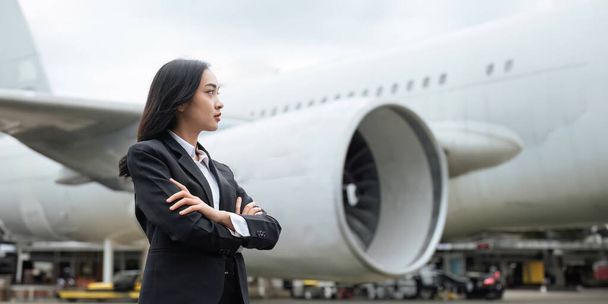 Mujer de negocios asiática profesional ejecutiva usando traje caminando en el aeropuerto mirando hacia otro lado pensando en el éxito, liderazgo Joven empresaria asiática confiada y profesional. - Foto, Imagen