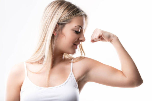 Fitness-Fürsprecherin im lässigen Tank-Top feiert ihre muskulöse Leistung - Foto, Bild