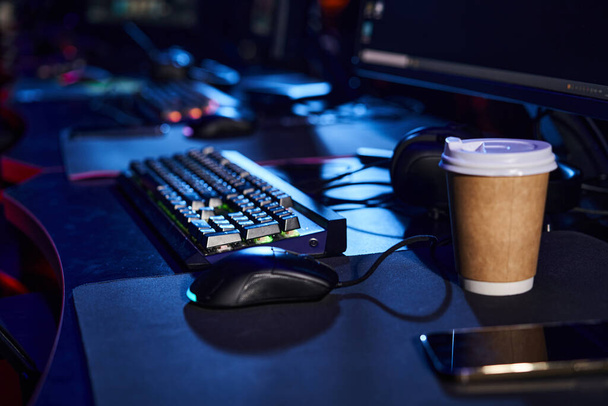 современная офисная установка с гладкой компьютерной клавиатурой и мышью на столе рядом с чашкой кофе - Фото, изображение