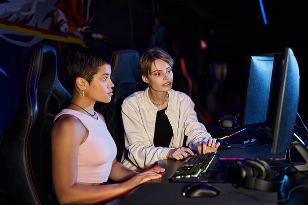 két nő összpontosított cybersport játék ülésen, fiatal játékosok gondolkodás játék stratégia - Fotó, kép