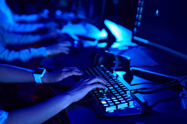 oříznutý záběr ženských rukou, mladý hráč pomocí počítačové klávesnice při hraní hry, kybersport - Fotografie, Obrázek
