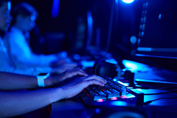 περικοπή φωτογραφία του γυναικεία χέρια, νεαρός gamer χρησιμοποιώντας πληκτρολόγιο υπολογιστή, ενώ παίζει το παιχνίδι, cybersport - Φωτογραφία, εικόνα