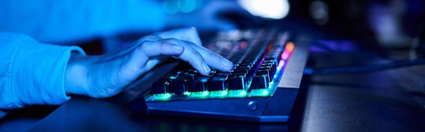banner de las manos femeninas recortadas escribiendo en el teclado de la computadora con iluminación, luz azul - Foto, imagen